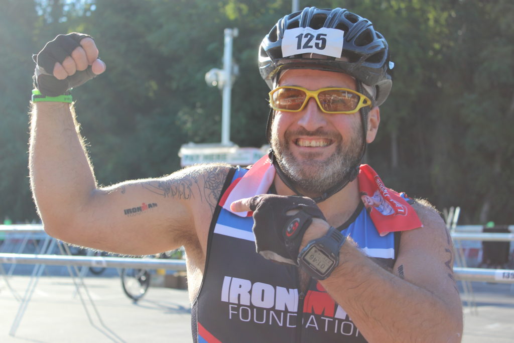TEAM IMF Athlete, Nader Tabbara, showing off his guns (and his awesome IMF tattoo) in T1 before the 114 mile bike ride!